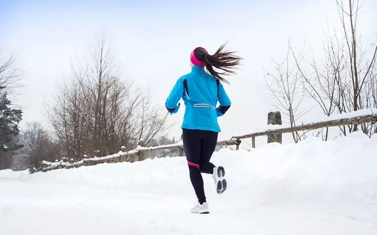 Woman running outdoors on a snowy path