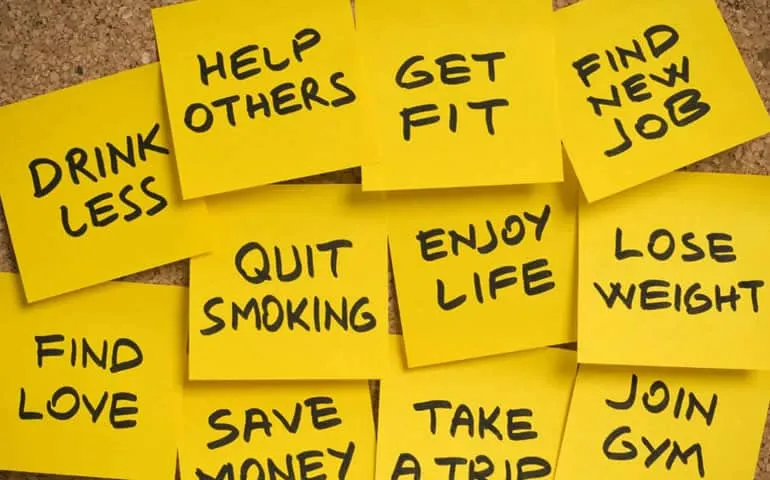Sticky notes with New Year's resolution goals like 'get fit' and 'quit smoking'