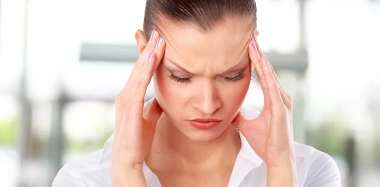 Woman holding her temples in pain from a headache