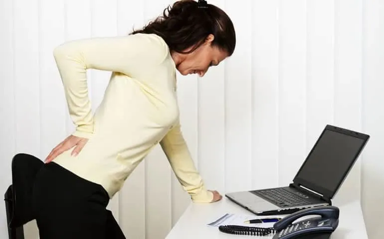 Woman hunched over a laptop with poor posture
