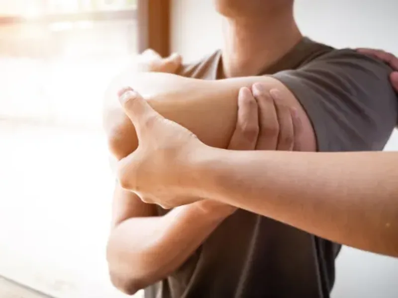 Physical therapist assessing a patient's shoulder and rotator cuff